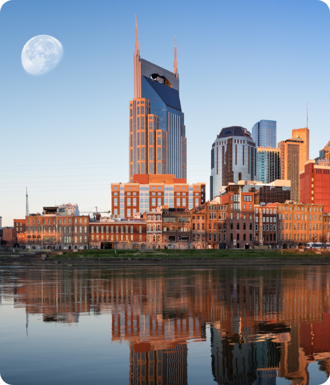 Nashville skyline with iconic AT&T building and moon, reflected in the Cumberland River.