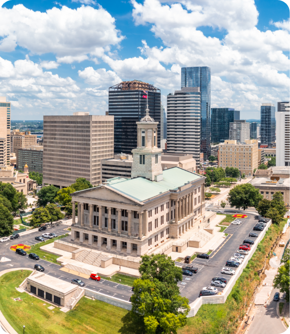 Aerial view of Nashville cityscape with a historic building and modern high-rises.